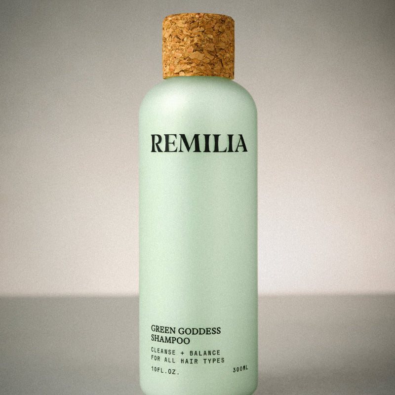 Green shampoo bottle with cork cap labeled 'Remilia' on a neutral background