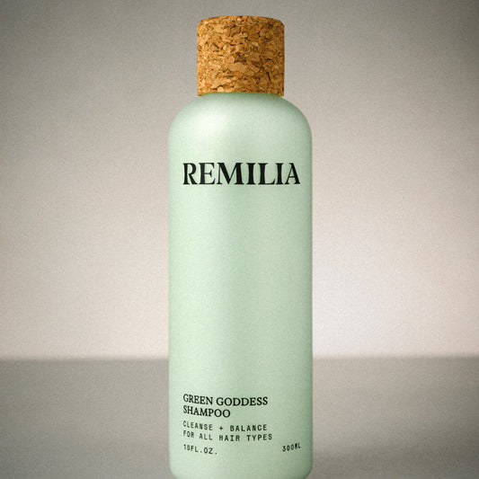 Green shampoo bottle with cork cap labeled 'Remilia' on a neutral background