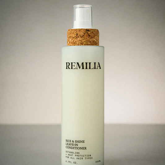 Bottle of Remilia leave-in conditioner with cork cap on a gray background